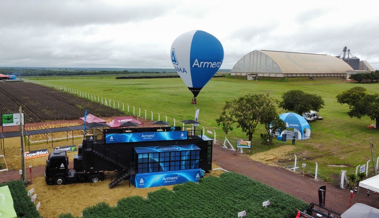 Imagem aérea do truck, balão e estande do Armero Experience em feira agropecuária.