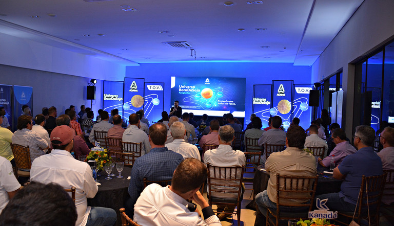 Foto geral do evento Universo Bom de Soja, com painel neon ao fundo