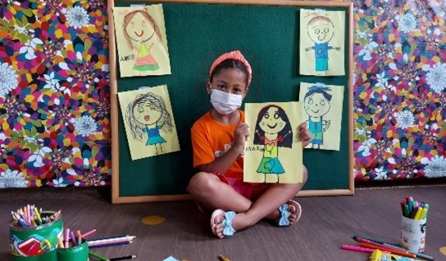 Kid in Brazil holding her drawing