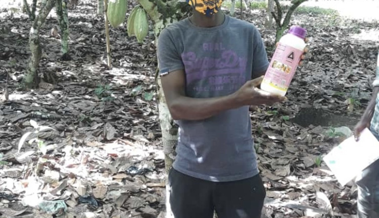 Cocoa farmer with ADAMA Cocoa solution in the field